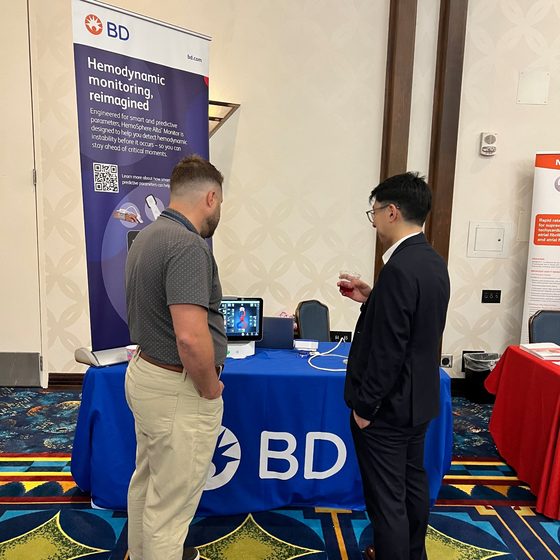 An exhibitor in conversation with an attendee at a CSA meeting