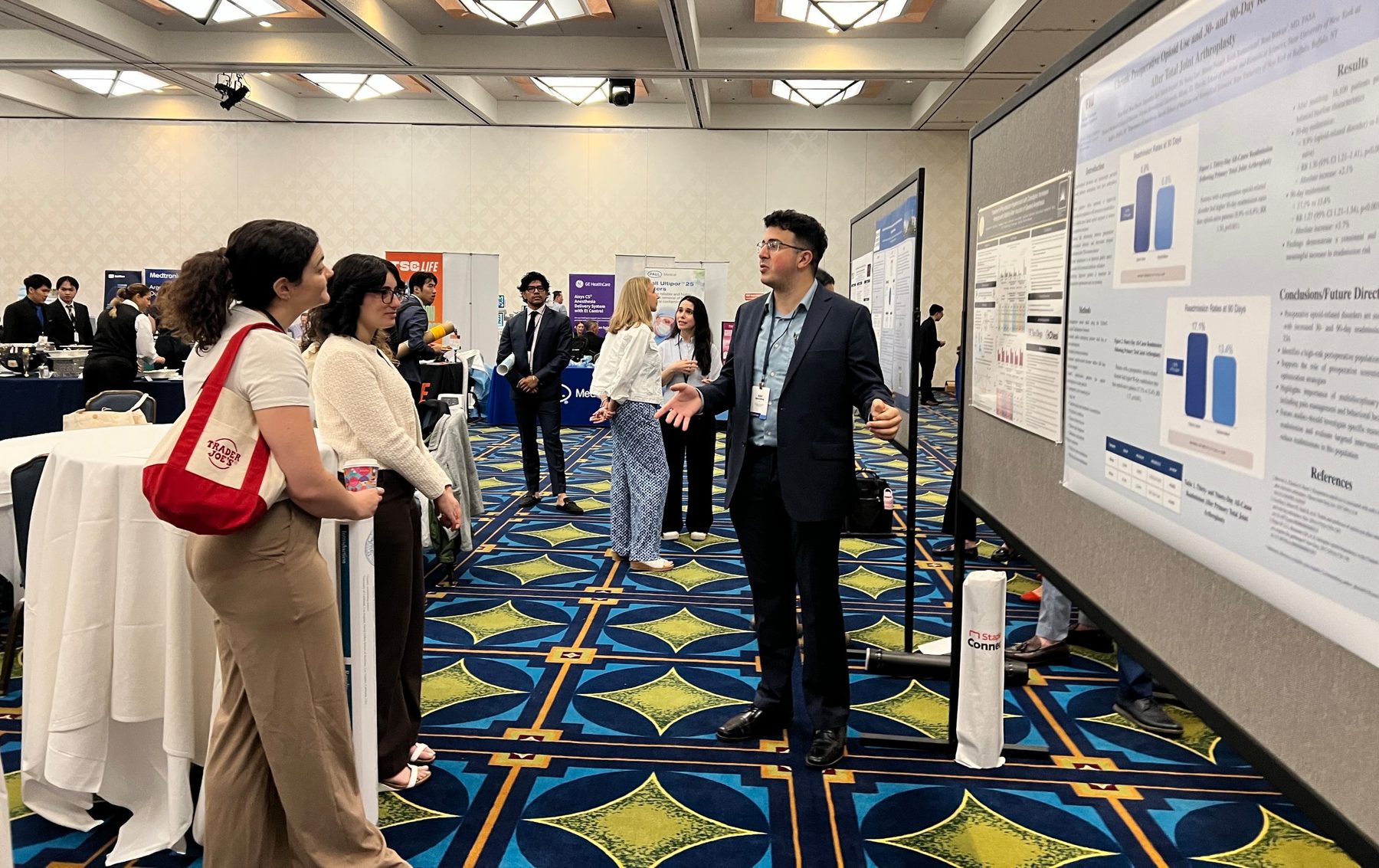 Presenter discussing his research poster with attendees