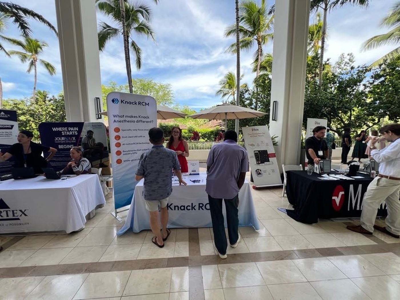Exhibitors and attendees talking on an open-air lanai at a CSA Hawaii conference